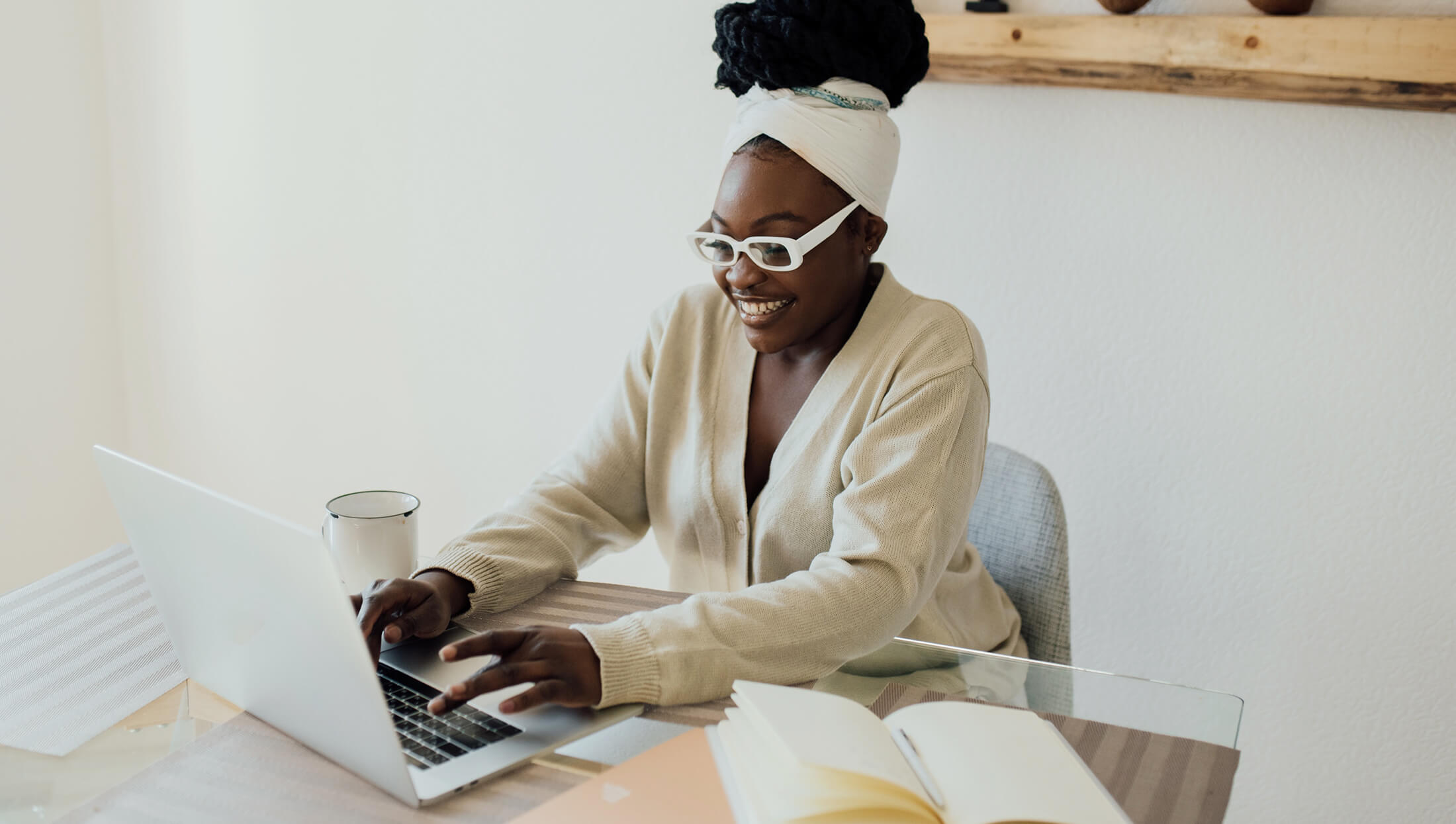 Happy black woman wearing glasses by her laptop
